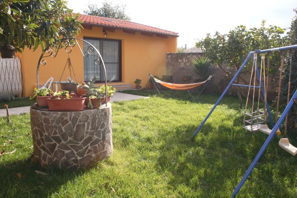 un cortile con amaca e una casa di Casa Vacanze Margherita a Riola Sardo