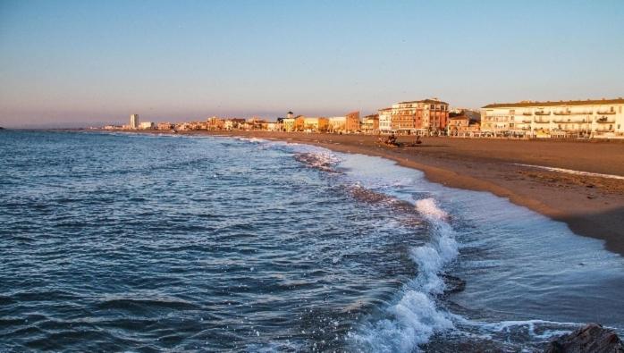 une vue d'une plage avec des bâtiments et l'océan dans l'établissement Studio avec grande terrasse 2 personnes à Valras plage, à Valras-Plage