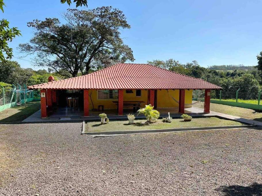 mały żółty dom z czerwonym dachem w obiekcie Chalé Rural - Haras Gabriela TC w mieście Nova Esperança