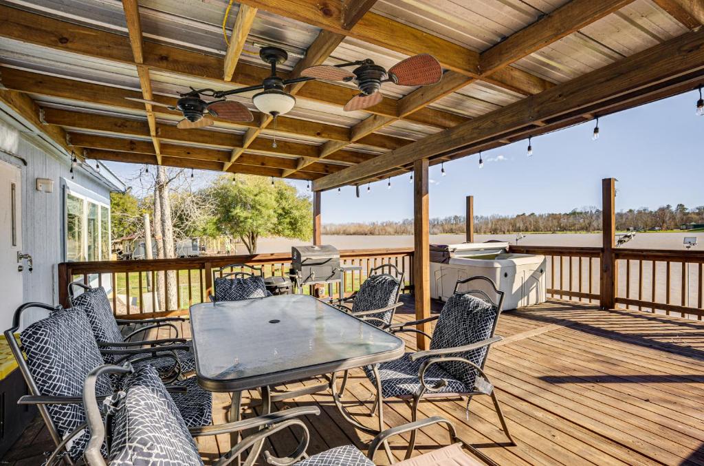 un patio con mesa y sillas en una terraza en Waterfront Trinity Vacation Rental with Hot Tub!, en Riverside