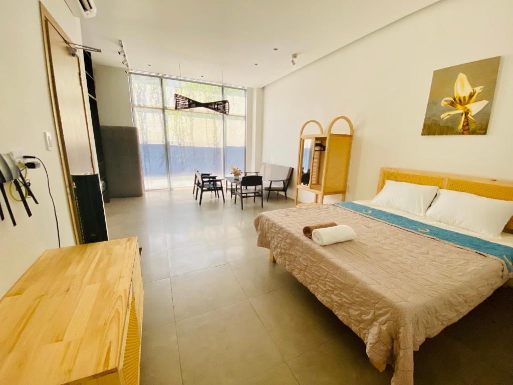 een slaapkamer met een groot bed en een eetkamer bij Dori House in Gò Công