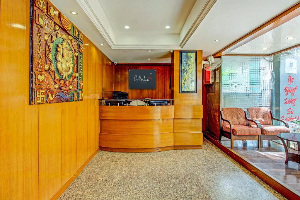 a lobby with a waiting area with two chairs at Capital O Sri Krishna Suites Near 7d Voyage in Bangalore