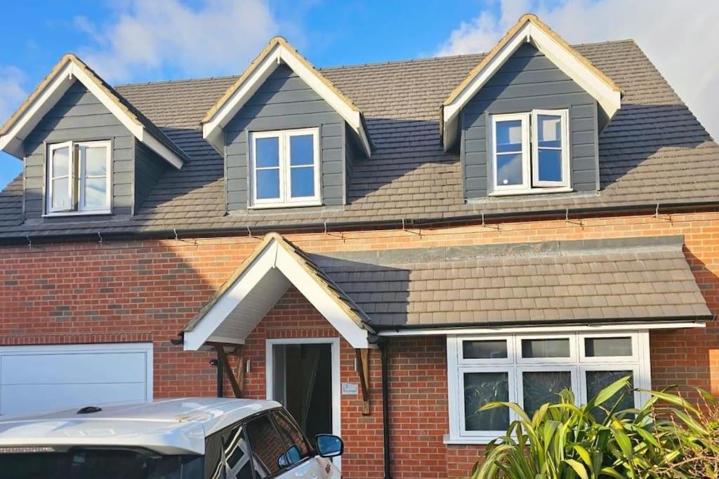 a house with a car parked in front of it at Stunning 4 bed house in Rolleston