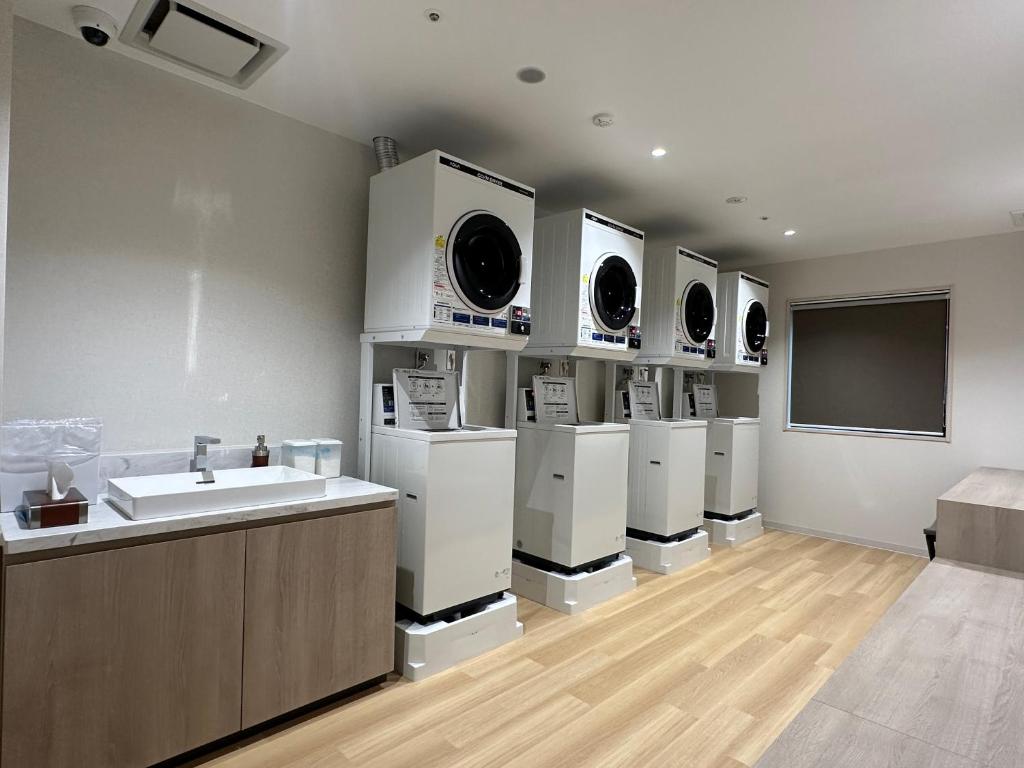 a room with a sink and a bunch of white appliances at Spa World HOTEL&RESORT in Osaka