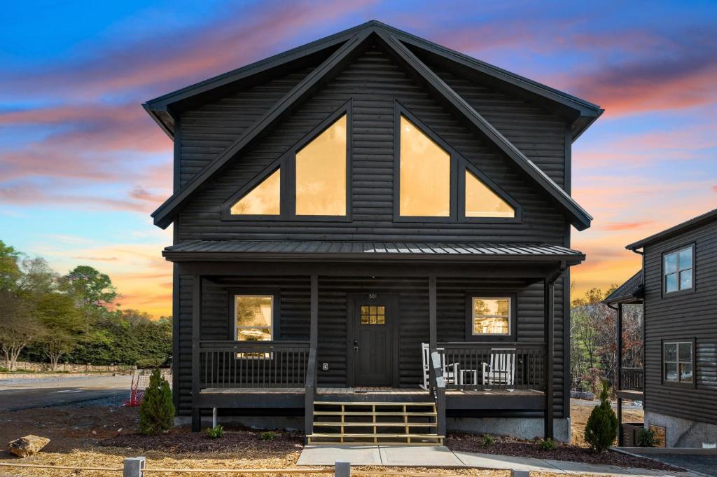 a black house with a gambrel roof at SmokiesBoutiqueCabins would love to host you at our NEW cabin! 3 King Suites, Indoor Pool, Game Room, Lounge with 75" TV! Close to Dollywood and the Parkway! in Pigeon Forge
