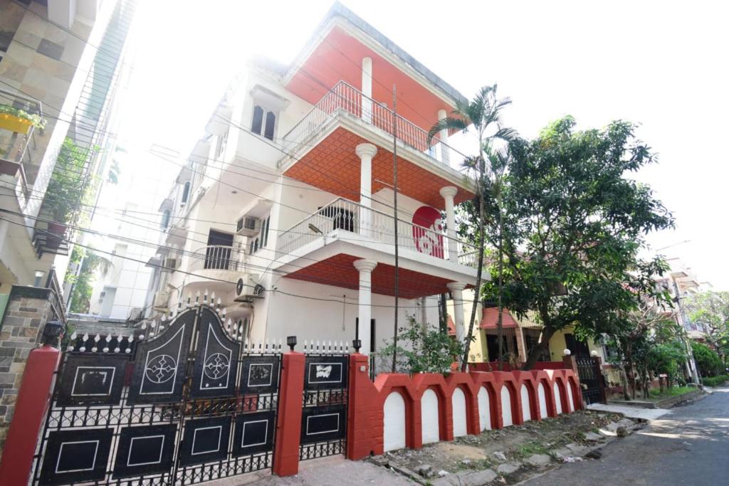 a red and white house with a fence at GRG Hotel Wow Inn Kolkata in Salt Lake City