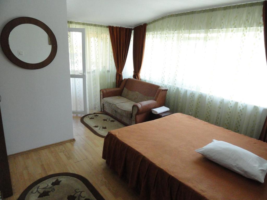 ピテシュティにあるPensiune Restaurant Avangardeのベッドルーム1室(ベッド1台、椅子、鏡付)