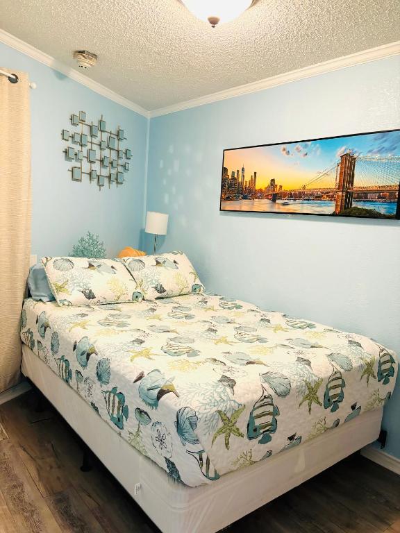 a bedroom with a bed and a painting on the wall at Beautiful newly renovated beachfront condo at Casa Del Mars in Galveston