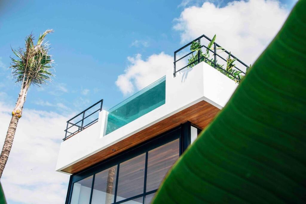 a house with a palm tree on top of it at Baliwood Villas - OCEAN VIEW 3BR in Canggu