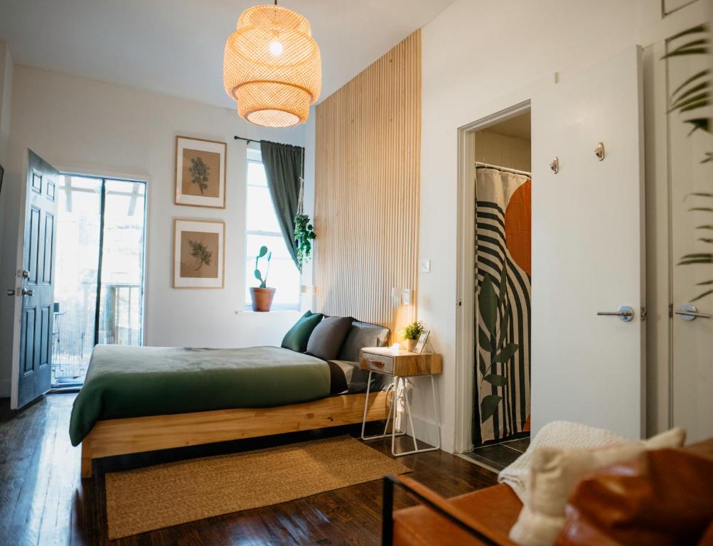 a bedroom with a bed and a living room at Private room with private bathroom and backyard in Brooklyn