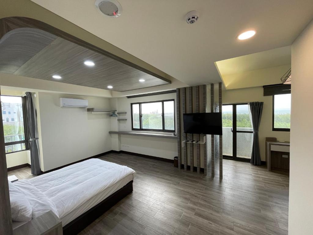 馬公市的住宿－攜蔚貳館包棟民宿，一间卧室配有一张床和一台平面电视