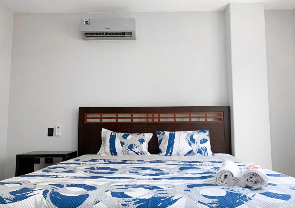 a bedroom with a bed with towels on it at Departamento de 3 dormitorios cerca al Mall San Marino in Guayaquil