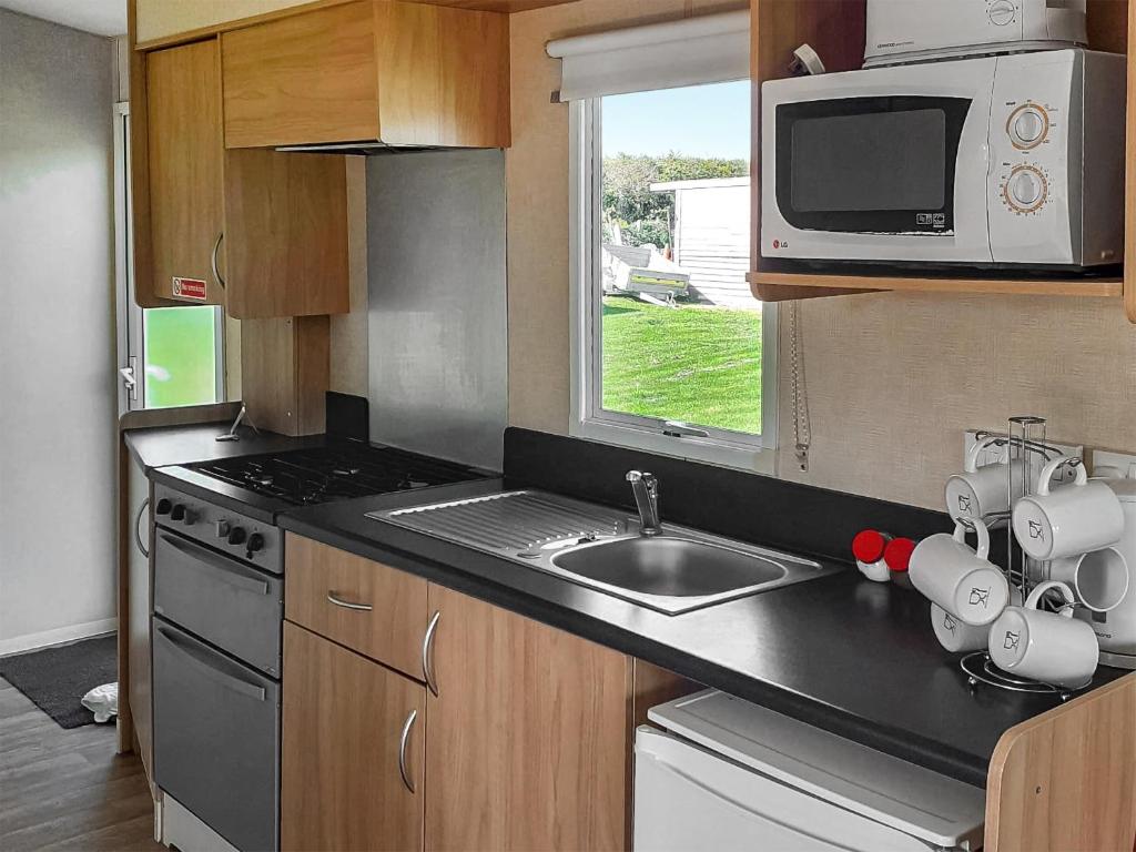 a kitchen with a sink and a microwave at Wren - Uk41949 in Louth