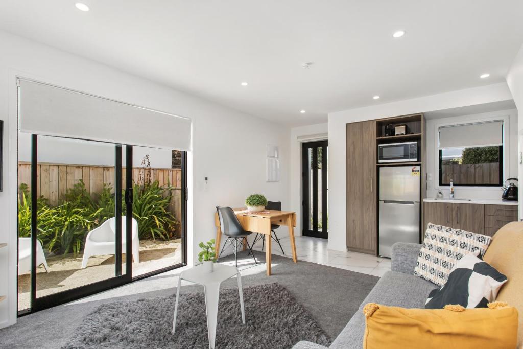 a living room with a couch and a table at Charming Sunny Warm 10 Mins CBD Book Now in Christchurch