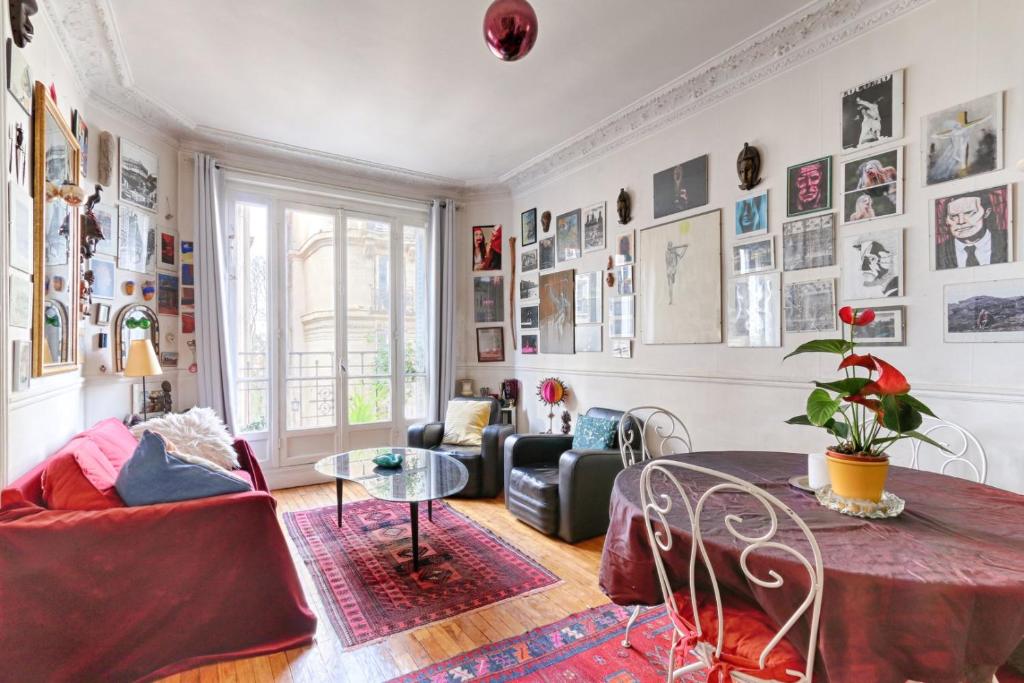 sala de estar con mesa y sofá en Résidor - Apartment in the heart of Montmartre, en París