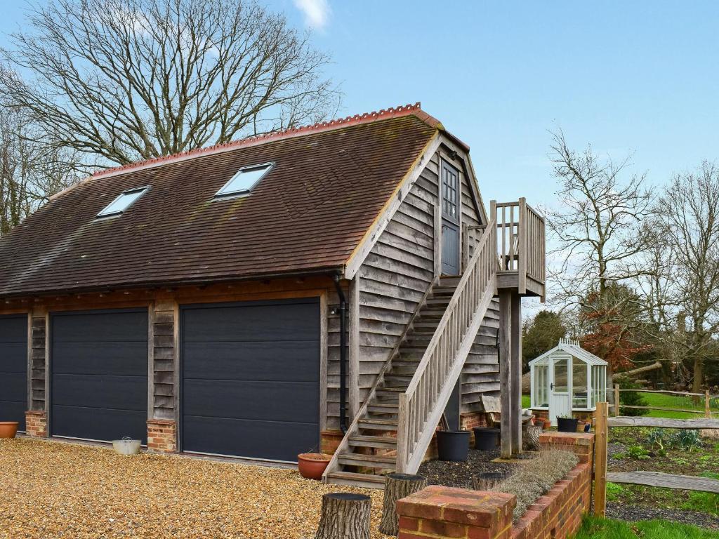 uma garagem com um telhado de gambrel e uma porta de garagem em Old Chimneys Studio em Lewes