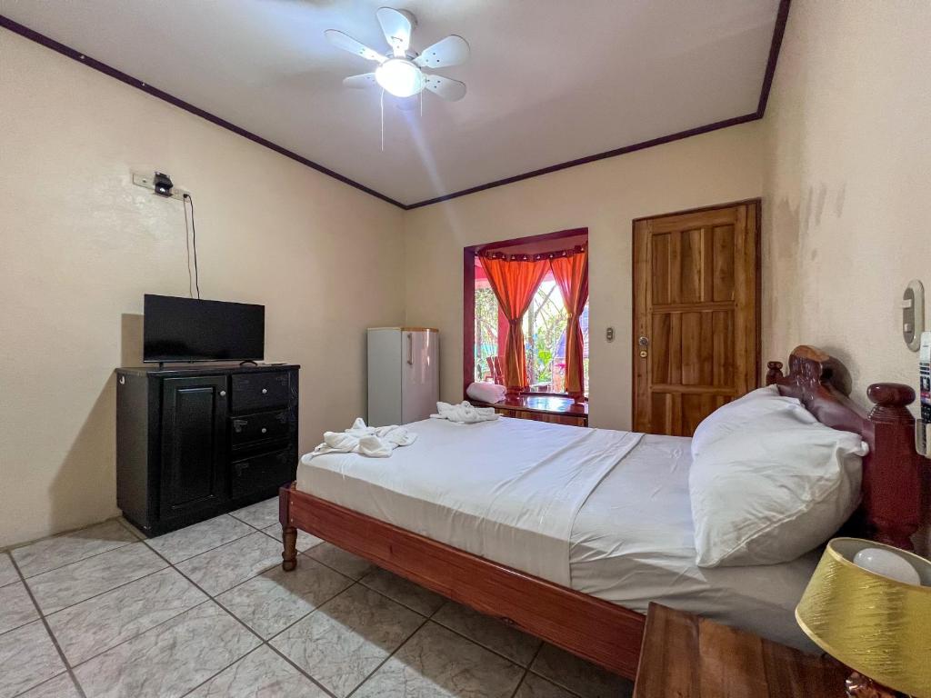 um quarto com uma cama grande e uma televisão em Ruta Corcovado em Puerto Jiménez