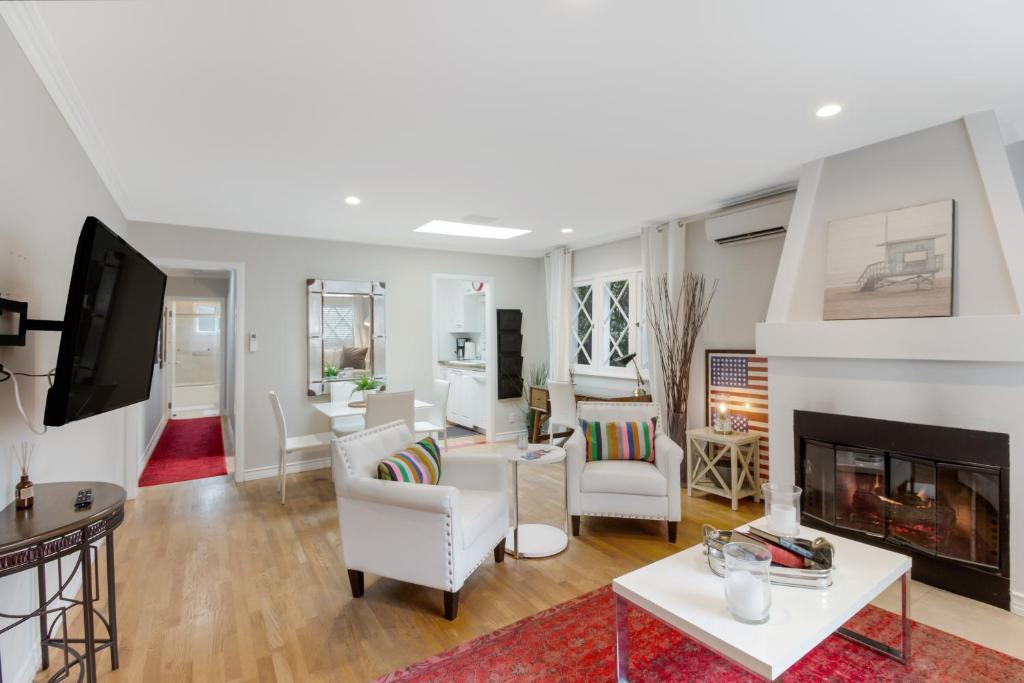 a living room with white furniture and a fireplace at COZY HOUSE IN WEHO in Los Angeles