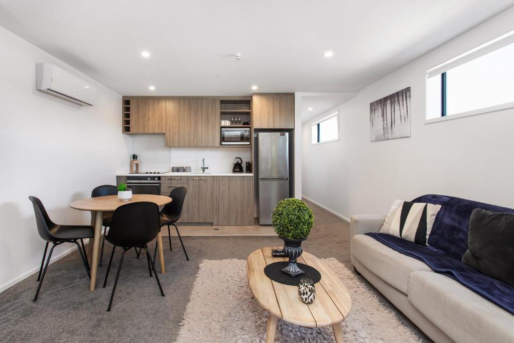 a living room with a couch and a table at Affordable Apartment Hagley Park Super Fast Wifi in Christchurch