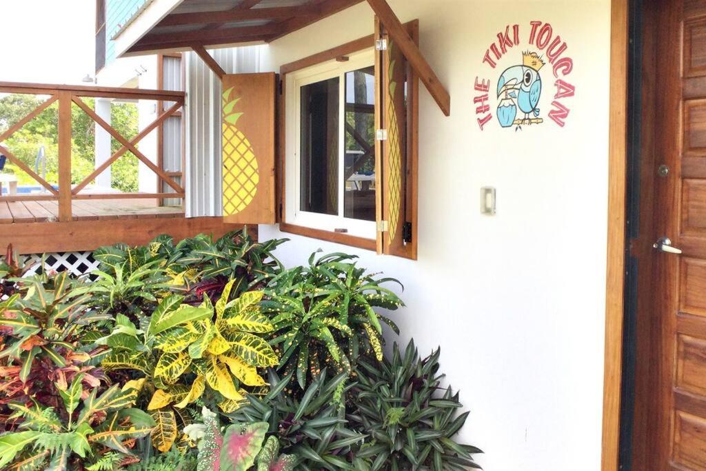 a building with a window and plants on the side at The Tiki Toucan Tropical Suite + Private Pool in Placencia Village