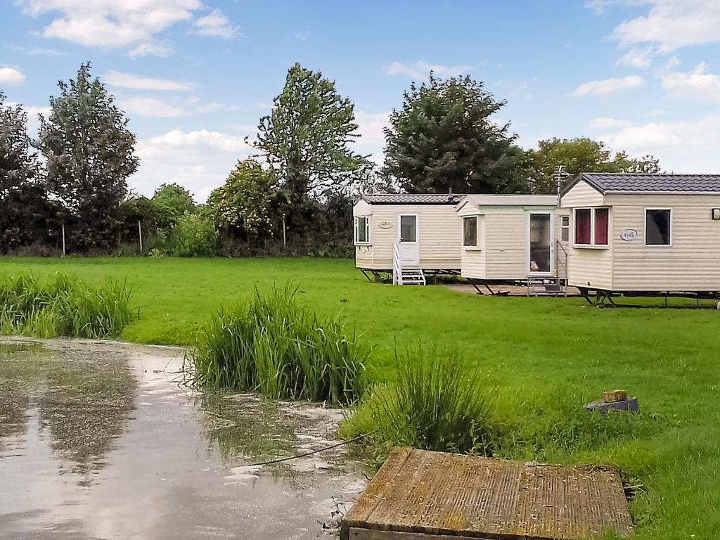 a mobile home and a caravan in a field at Kingfisher - Uk41950 in Louth