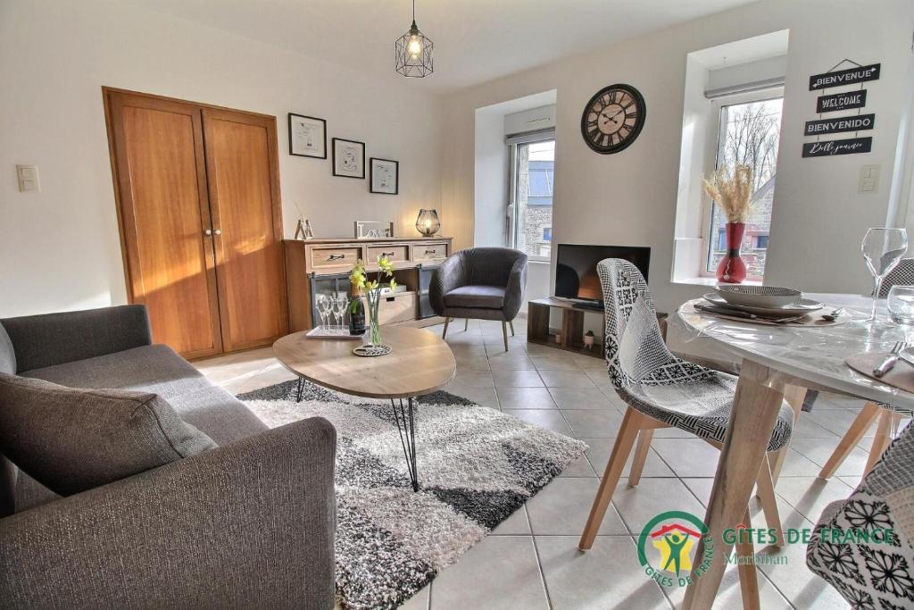 Le gite de marie في Monterblanc: غرفة معيشة مع أريكة وطاولة وكراسي