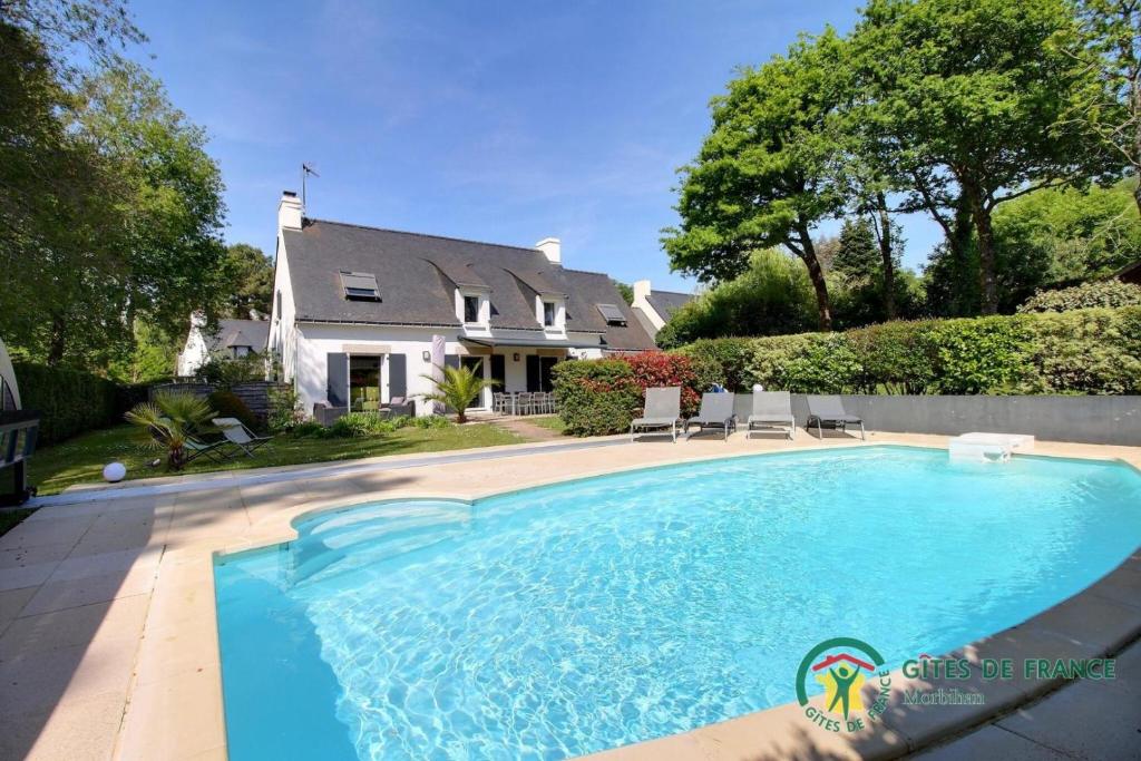 - une piscine en face d'une maison dans l'établissement Villa mimosas, à Brech