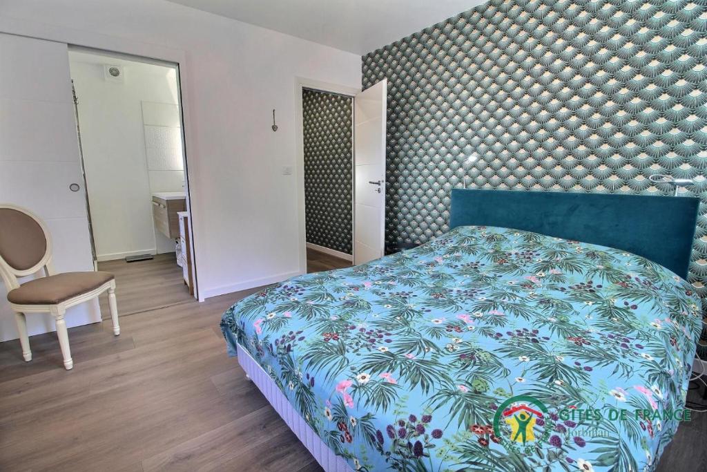 a bedroom with a blue bed and a chair at Villa mimosas in Brech