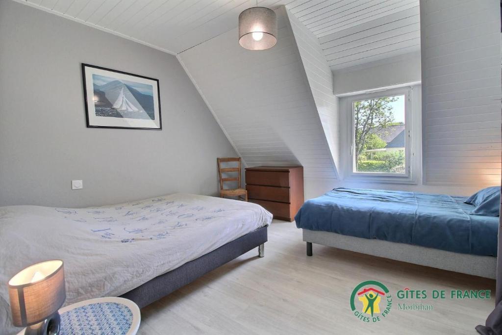 a bedroom with two beds and a window at Villa mimosas in Brech