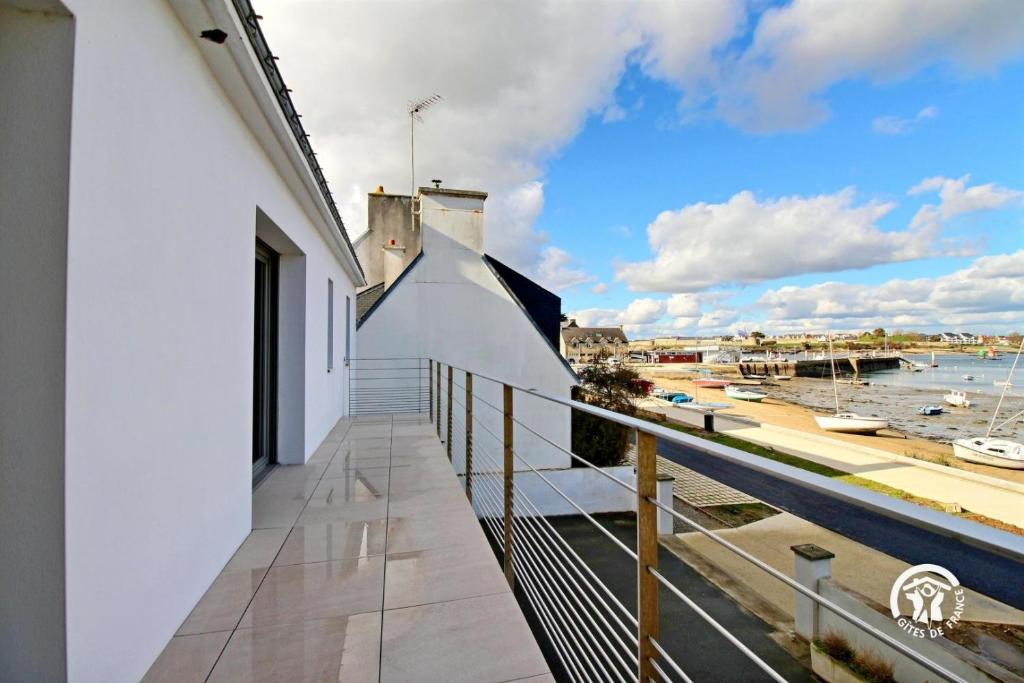 ein Balkon eines Hauses mit Blick auf das Wasser in der Unterkunft Ty rigadeau in Gâvres