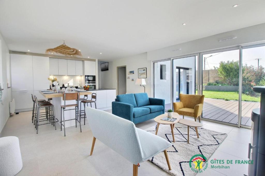 - un salon et une cuisine avec un canapé bleu et des chaises dans l'établissement Ty anel, à Auray