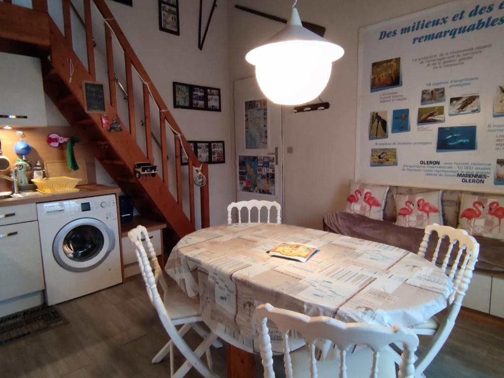 uma cozinha com uma mesa e cadeiras e uma máquina de lavar roupa em Maison Dolus-d'Oléron, 3 pièces, 4 personnes - FR-1-778-2 em Dolus