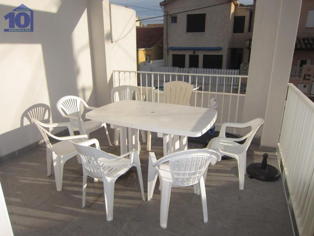 uma mesa branca e cadeiras numa varanda em Maison Valras-Plage, 3 pièces, 6 personnes - FR-1-781-22 em Valras-Plage