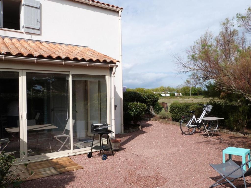 un patio de una casa con ventana y parrilla en Maison La Tranche-sur-Mer, 3 pièces, 4 personnes - FR-1-194-279, en La Tranche-sur-Mer