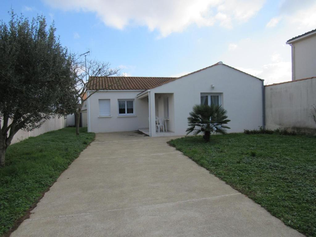 ein weißes Haus mit einem Bürgersteig davor in der Unterkunft Maison L'Aiguillon-sur-Mer, 3 pièces, 6 personnes - FR-1-194-277 in LʼAiguillon-sur-Mer