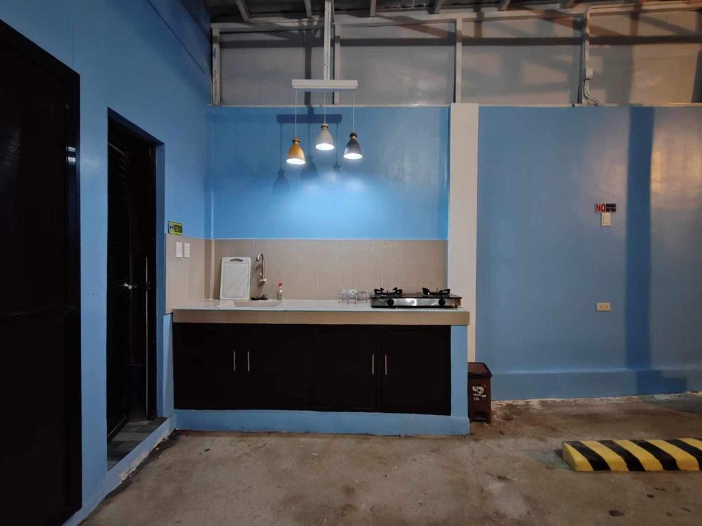 een keuken met een wastafel en een blauwe muur bij Patterville Transient House #4 in Iba