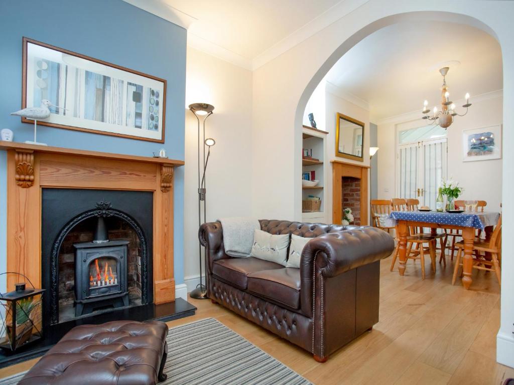 a living room with a couch and a fireplace at Hill View in Sidmouth