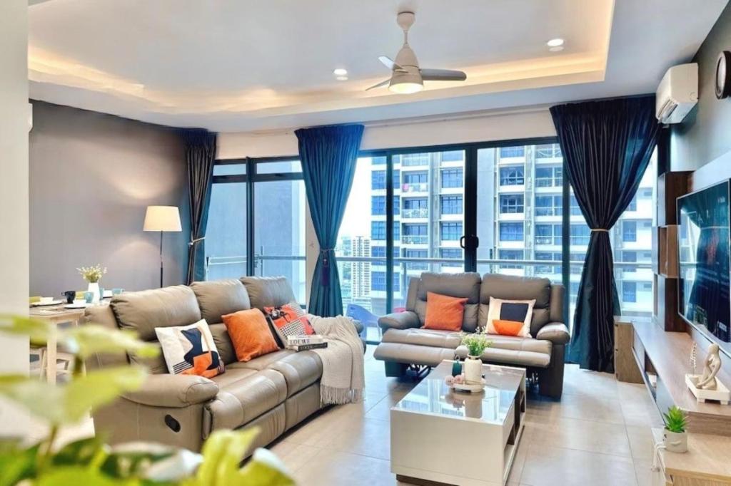 a living room with couches and a large window at Atlantis Residences Melaka in Melaka