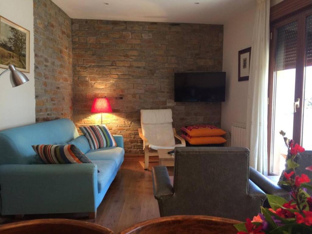 ein Wohnzimmer mit einem blauen Sofa und einem Tisch in der Unterkunft 5 bedrooms house with wifi at Molinaseca in Molinaseca