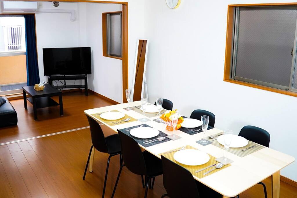 a dining room with a table with chairs and a television at NEW【駅から2分】USJ空庭難波梅田まで10分!まるごと一軒家貸し切り!大人数宿泊可能!駐車場有 in Osaka