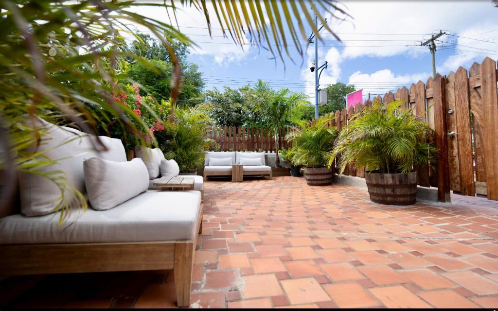 a patio with white couches and potted plants at The Monteray Hotel in Christ Church