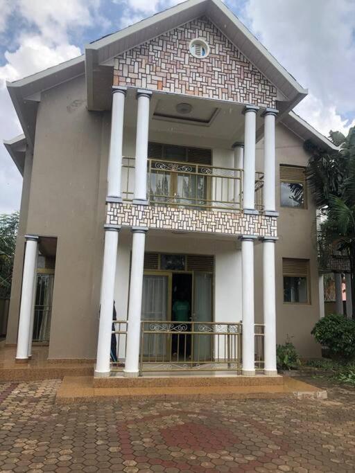 ein großes Haus mit einem Balkon auf der Vorderseite in der Unterkunft Cozy Homes Shared 1 in Kigali