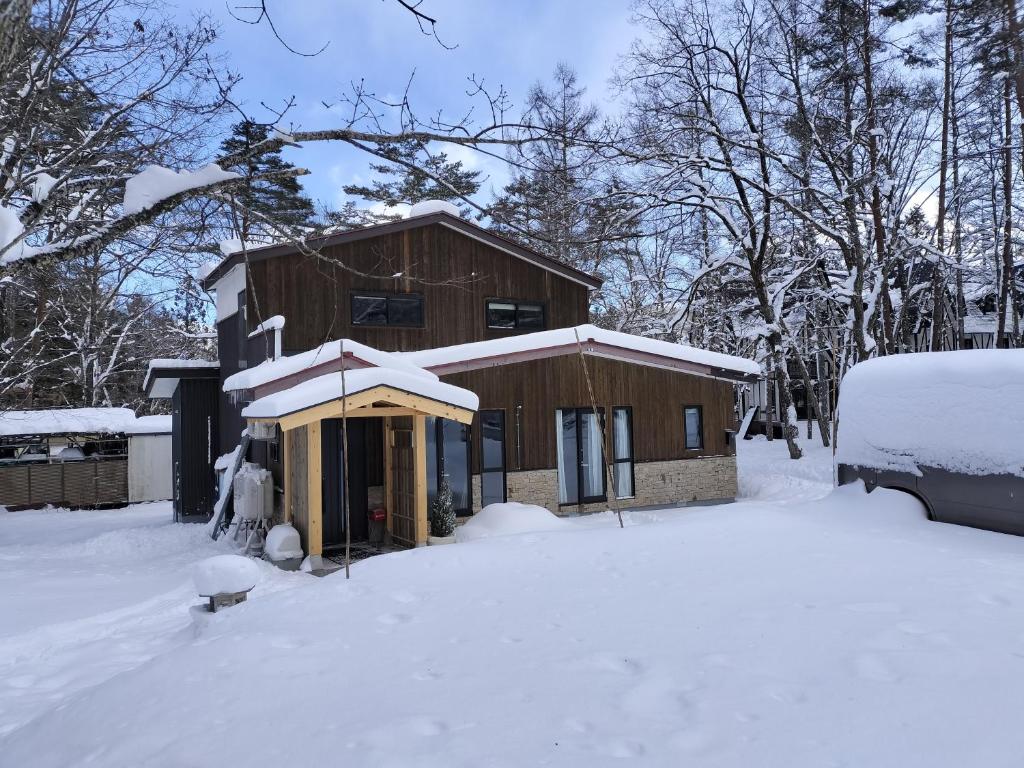 a house is covered in snow with snow at Nestle Inn Hakuba in Hakuba