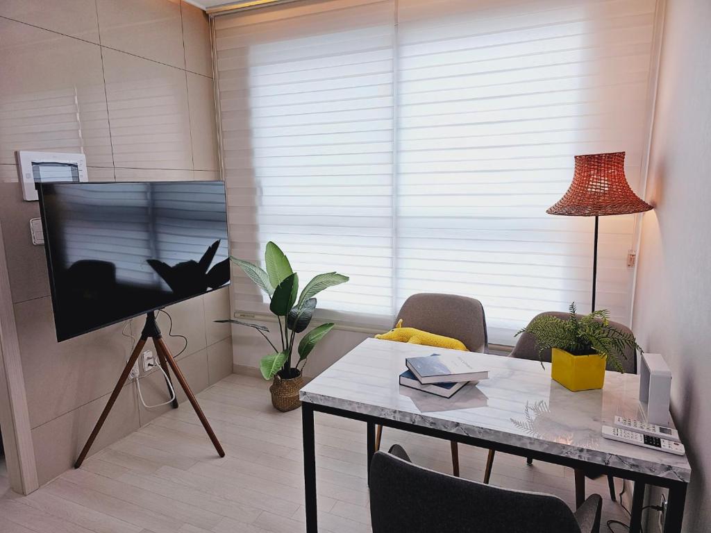 salon ze stołem i telewizorem z płaskim ekranem w obiekcie 서울의 야경이 멋진 옐로우 하우스 w Seulu