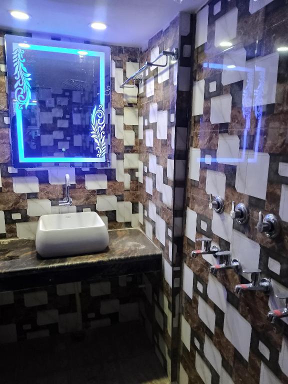 a bathroom with a sink and a monitor on the wall at Kishori ram guest house 5 minute walking distance from railway station in Ayodhya