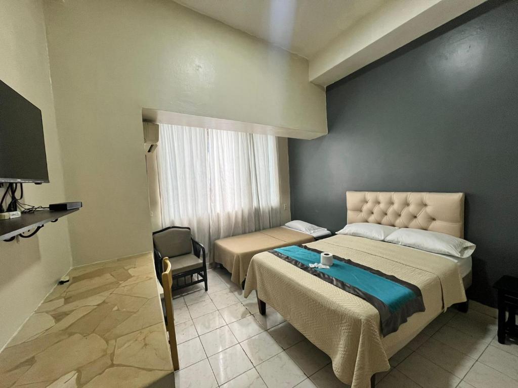 1 dormitorio con 1 cama grande y 1 silla en Atlantic Suites Hotel, en Guayaquil