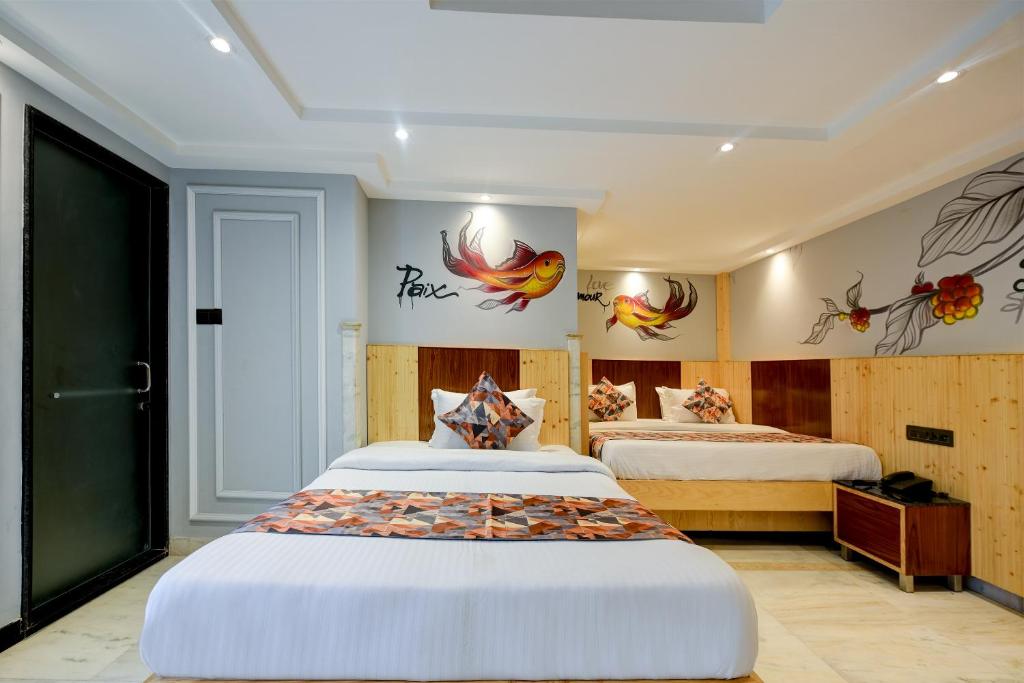 a hotel room with two beds and birds on the walls at Hotel Cottage Yes Please - New Delhi in New Delhi