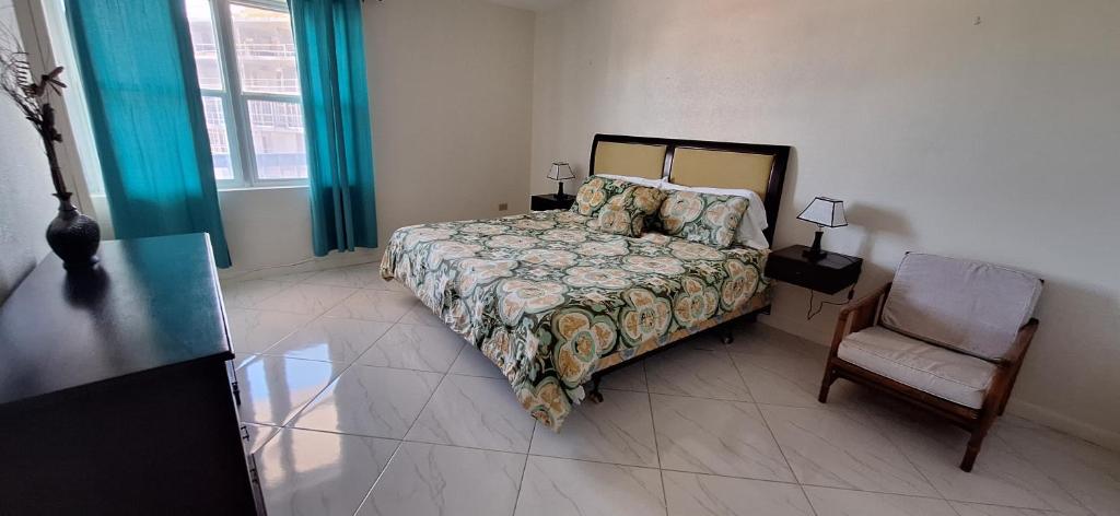 a bedroom with a bed and a chair at Seaview Property 3B Two Bedroom Apt Hasting Towers in Bridgetown