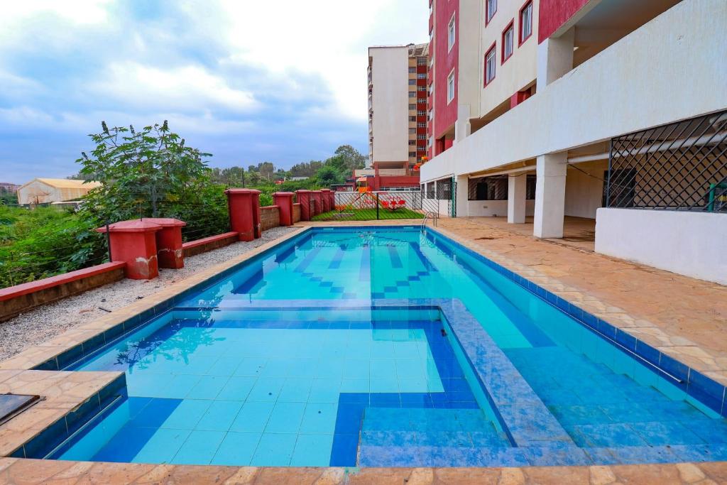 a swimming pool in front of a building at Omuts one bed airbnb with swimmingpool in Kiambu