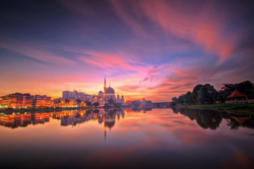 a view of a city at sunset from a river at Klang Prima Bayu Cozy 4-Room Retreat in Klang